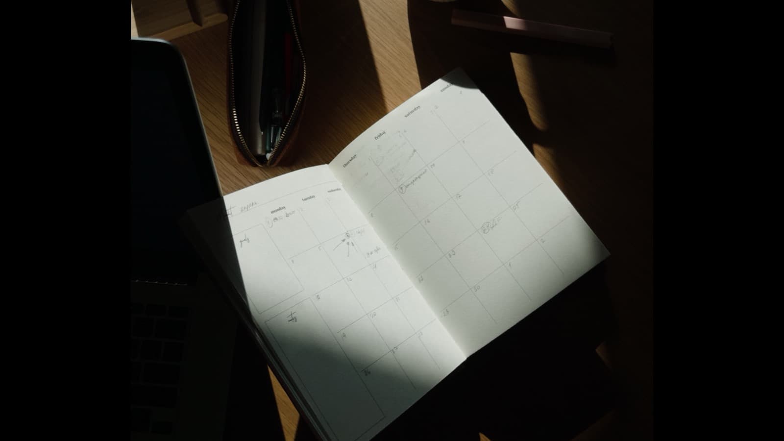 Open planner and coffee on a desk, planning the content schedule for the week