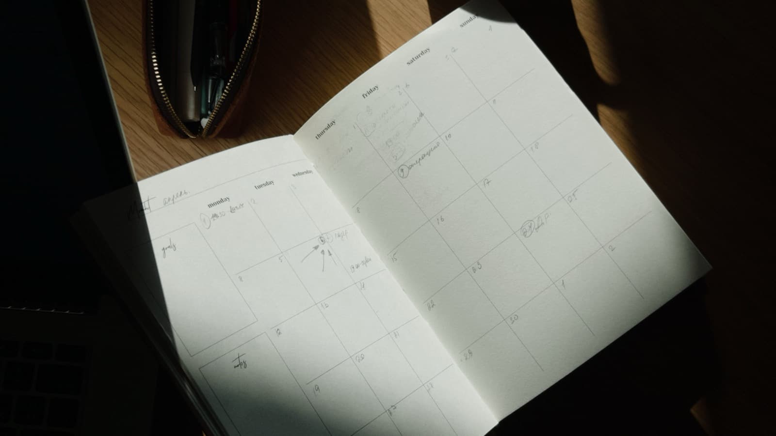 Open planner and calendar on a desk for scheduling content around a full-time job