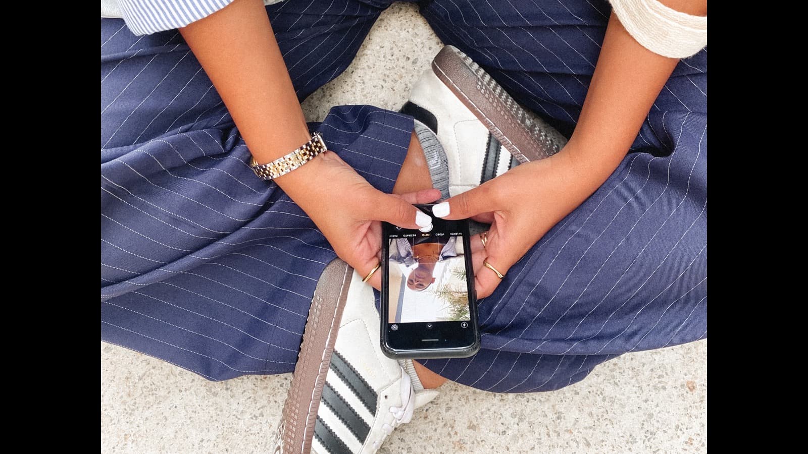 A person holding a phone while relaxing outdoors, balancing screen time with the real world