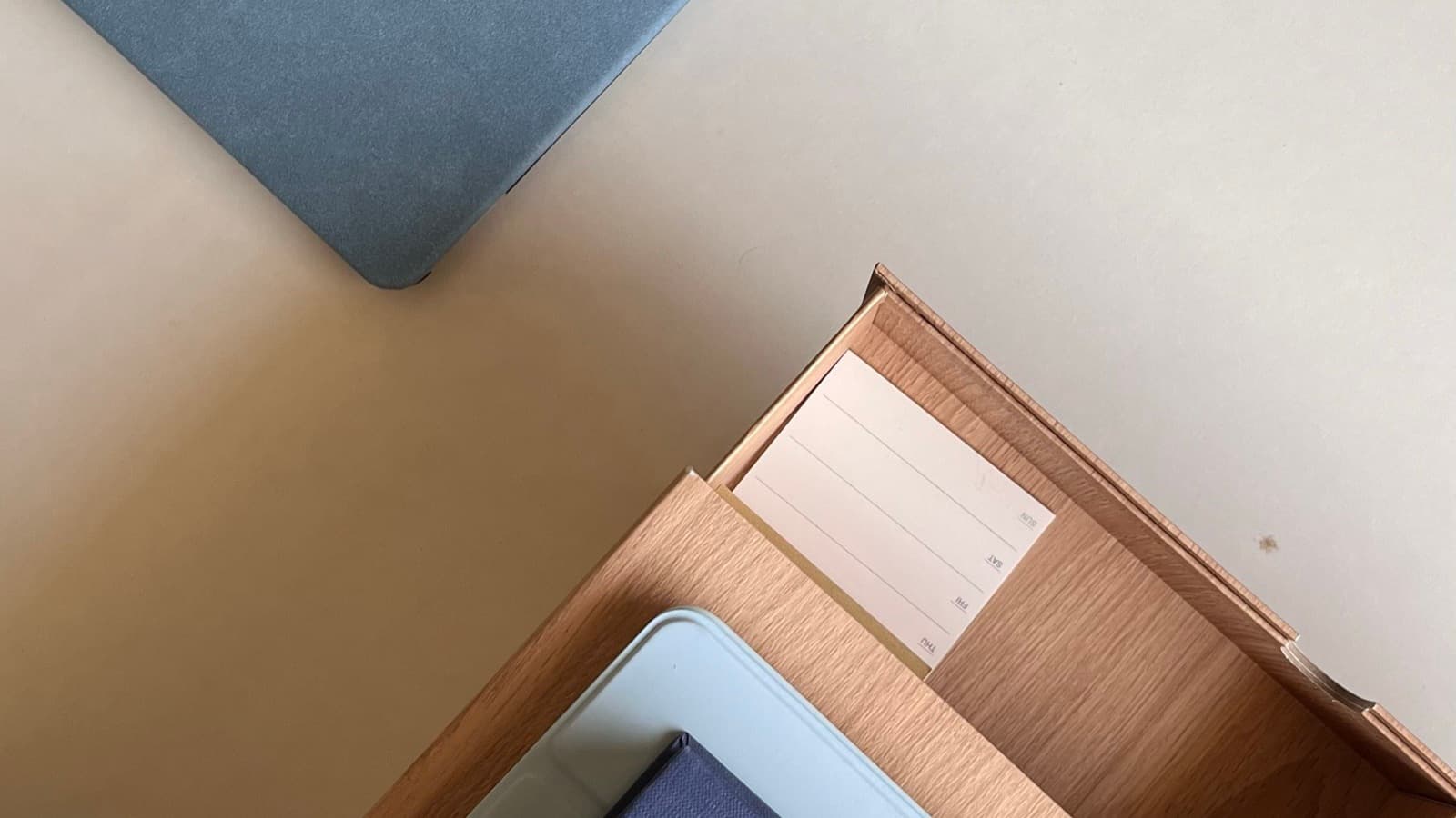 Desk with a document tray, notebook and tablet, representing paperwork