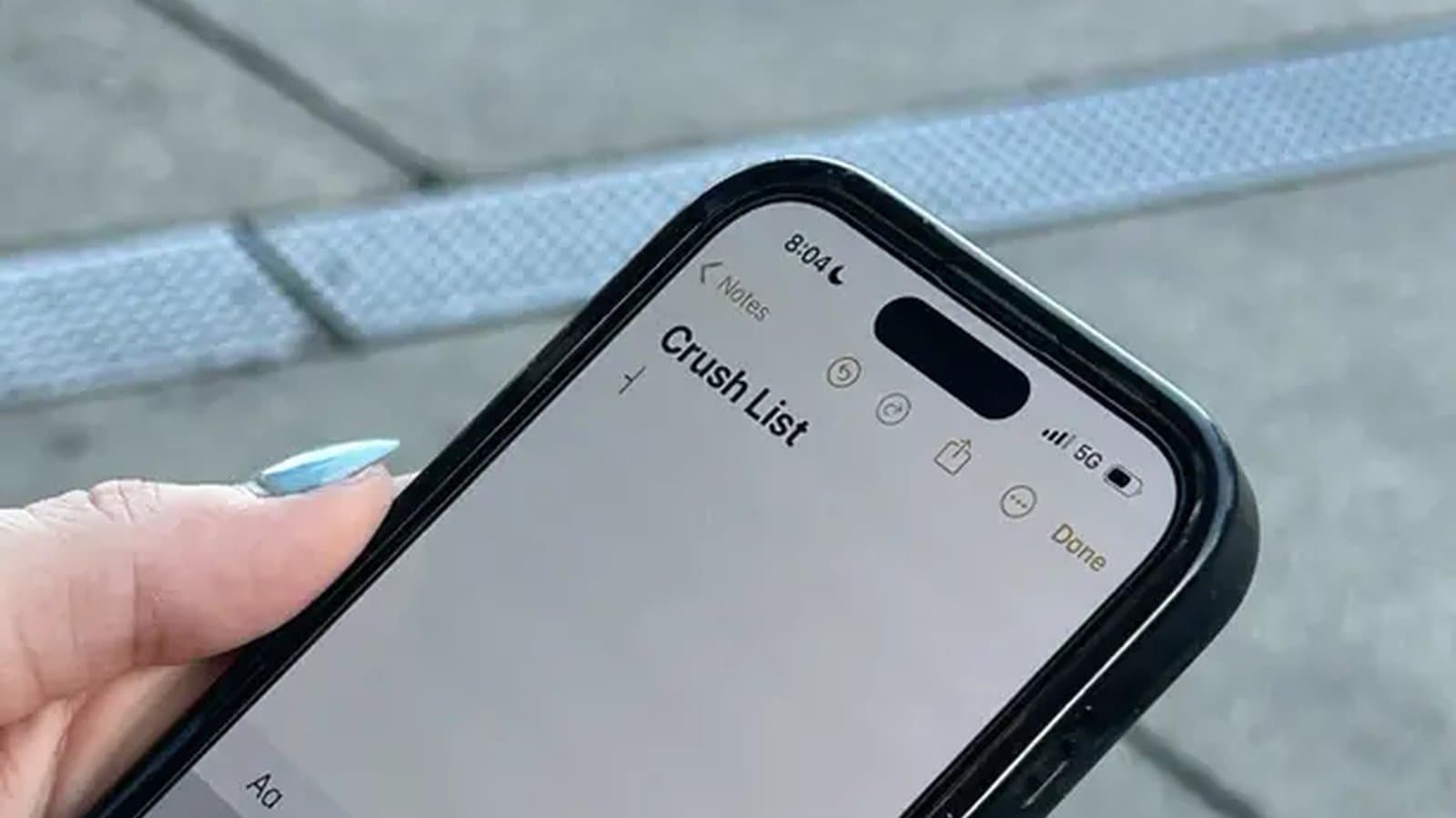 A smartphone showing a notes app with caption ideas and a keyboard