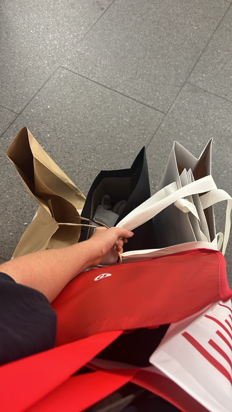 Person carrying shopping bags after a live shopping purchase