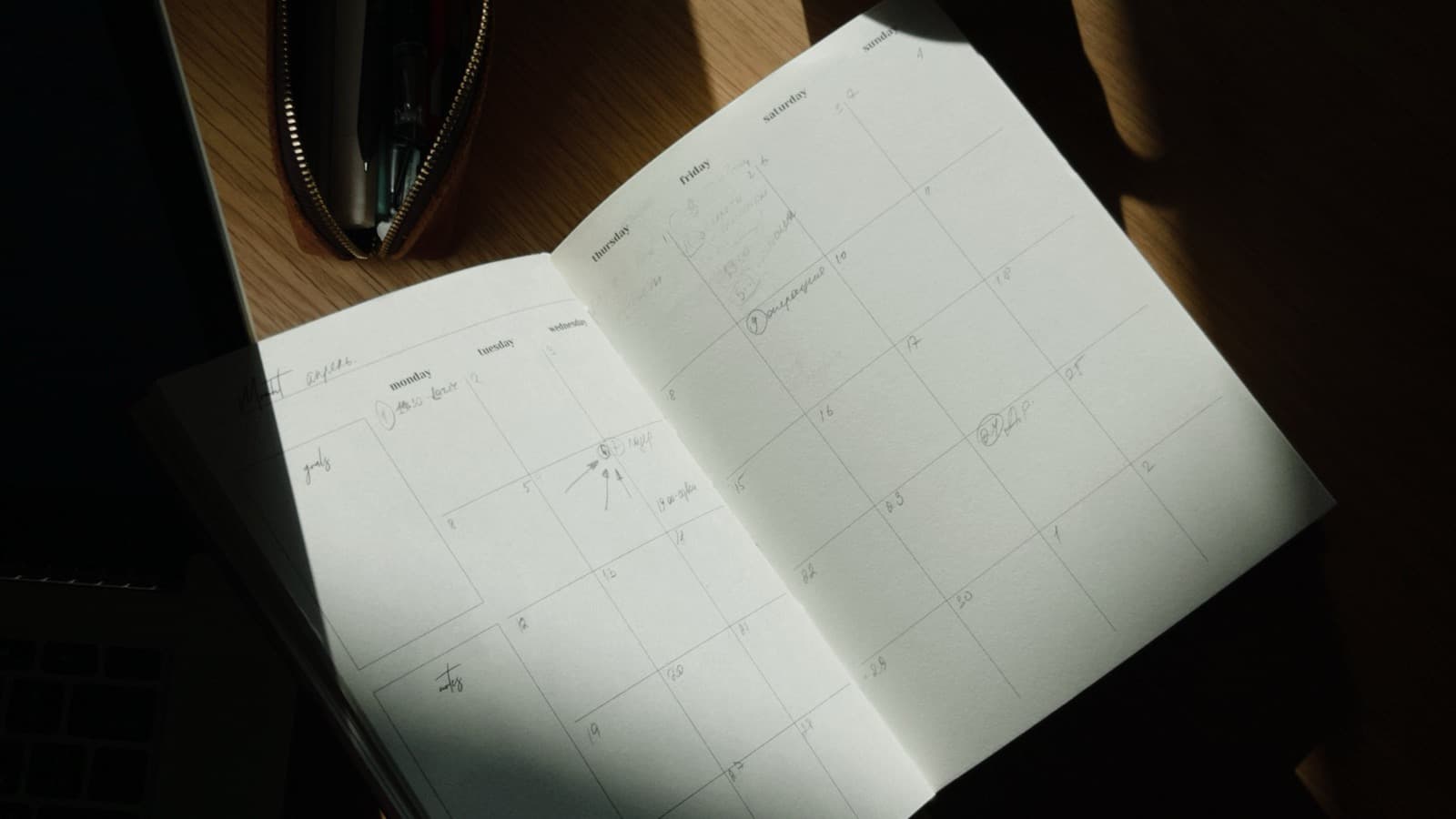 Open planner with a pen and notebook, representing quarterly content planning