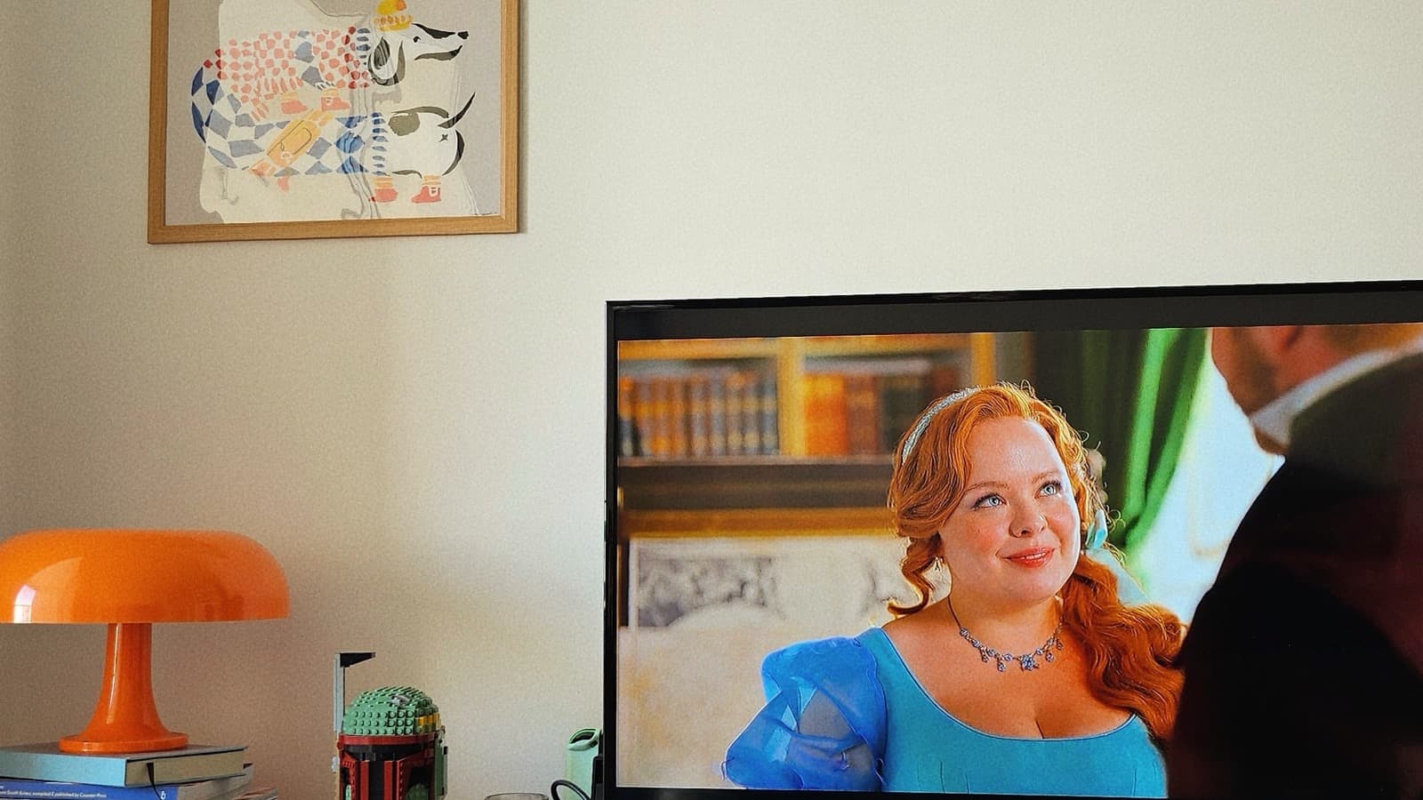 Person watching a show on a television in a bright living room, showing how playlists create binge sessions