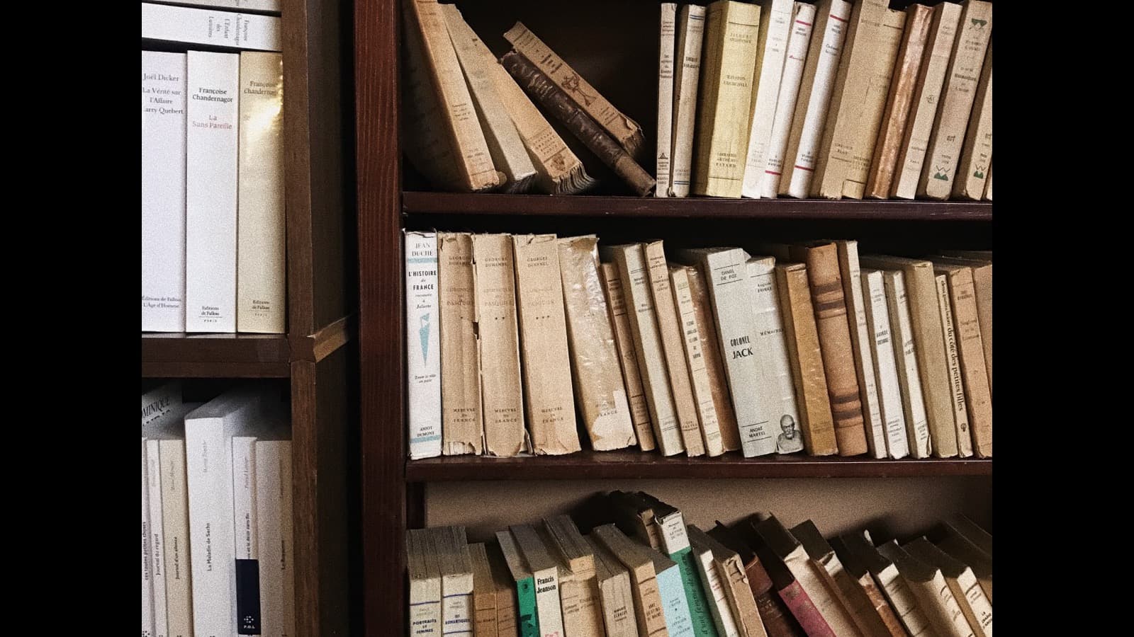 A stack of books beside a notebook, representing writing and self-publishing